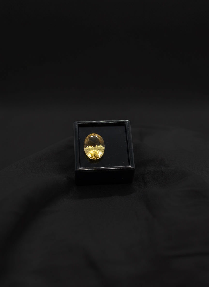 citrine quartz oval on top of a square black velvet  box, white linen background
