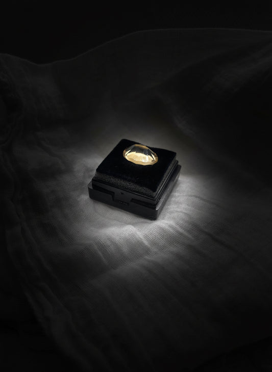 citrino cuarto oval cut over a square velvet box and clear background 