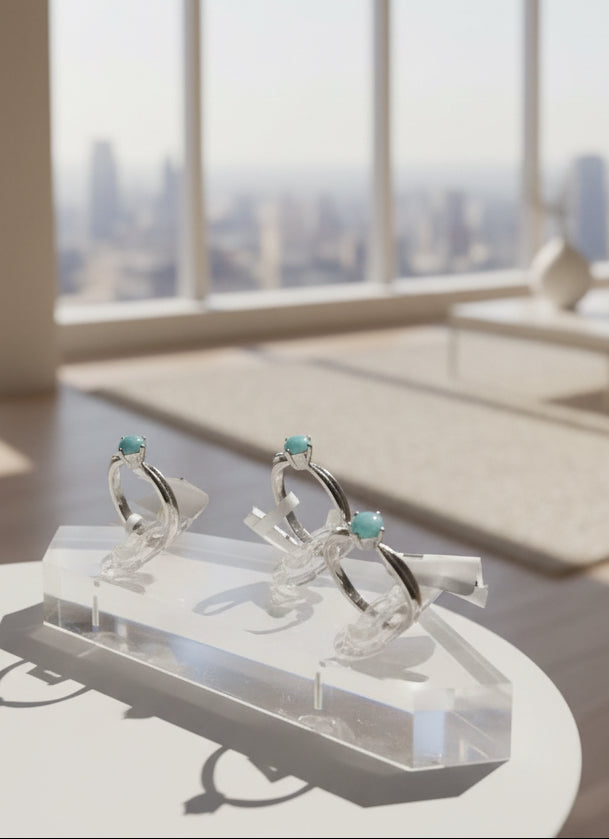 three rings with a light blue stone on a  holder 