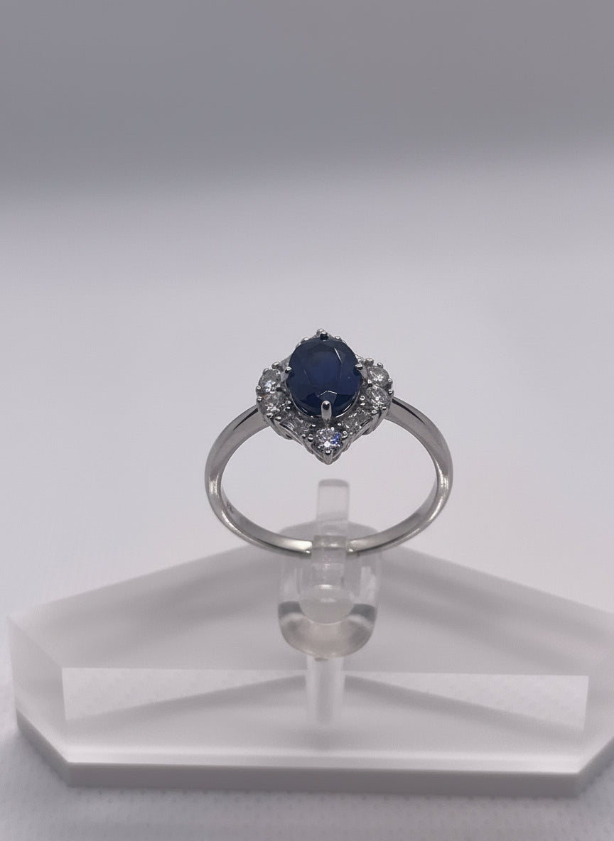 Silver ring with a blue gemstone on a white background