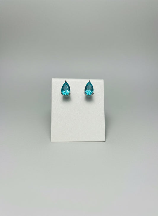 TWO BLUE NEAON STUD AND STERLING SILVER EARRIN ON A WHITE STAND 